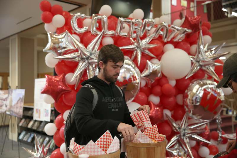 a man standing in front of a balloon display