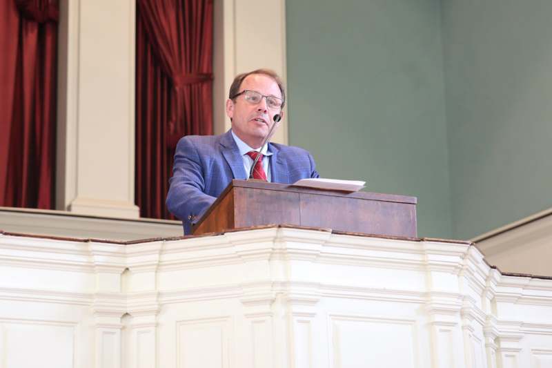 a man in a suit speaking at a podium