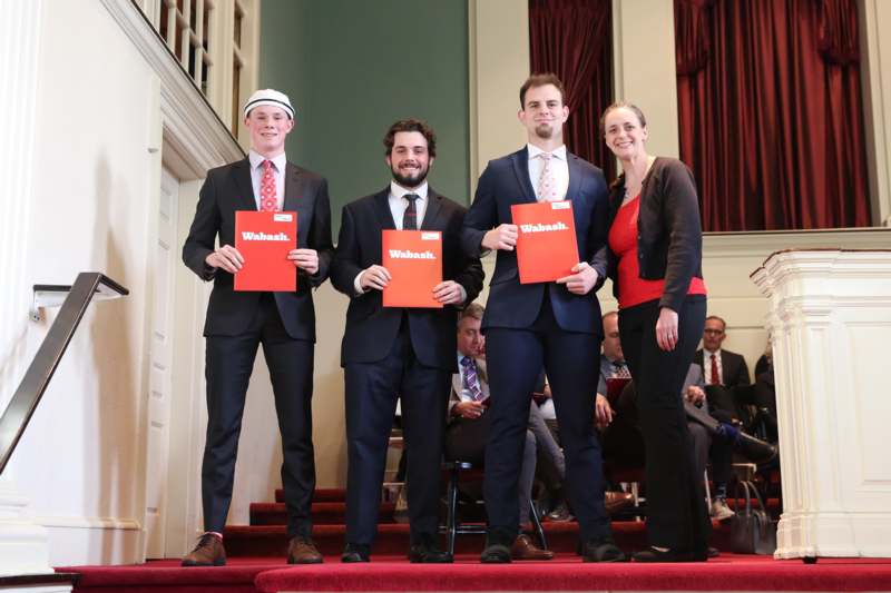 a group of people holding red papers