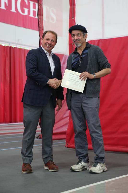 two men shaking hands with a certificate