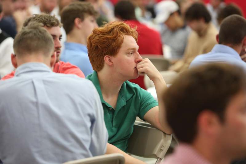 a man with red hair sitting in a classroom