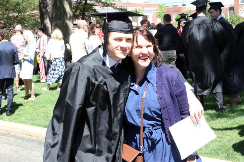 a man in a cap and gown with a woman in a graduation gown