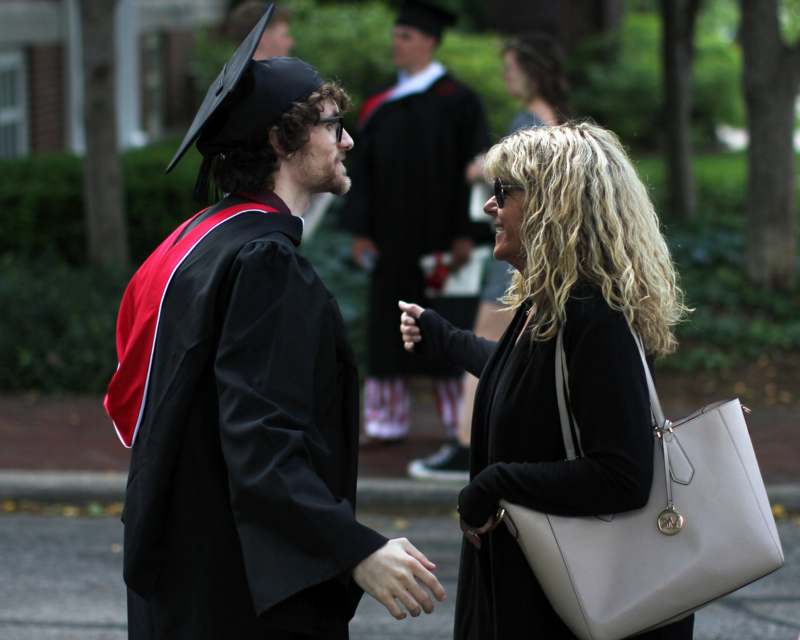 a man and woman in graduation gowns and cap talking