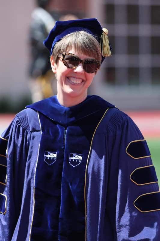 a woman wearing a graduation gown and sunglasses