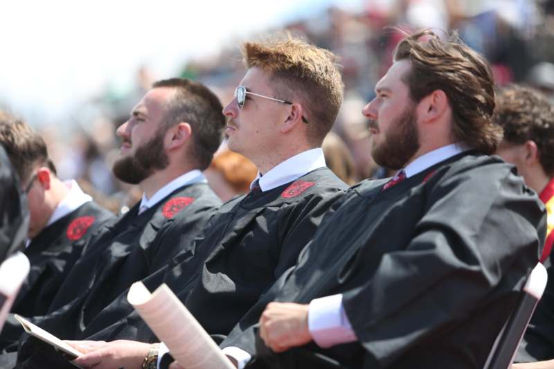 a group of men in black robes sitting in a row