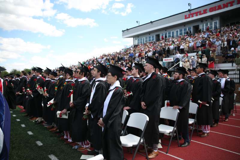 a group of people in graduation gowns and caps standing in a row
