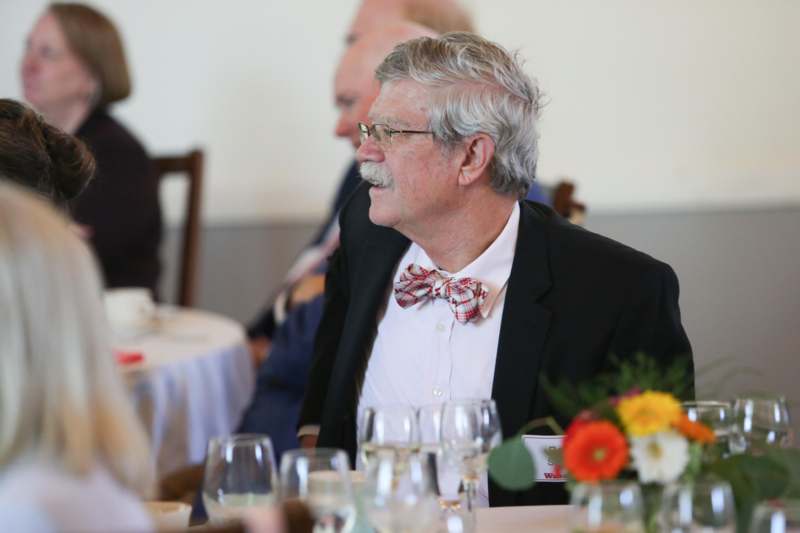 a man in a suit and bow tie sitting at a table