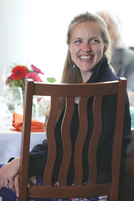a woman sitting at a table smiling