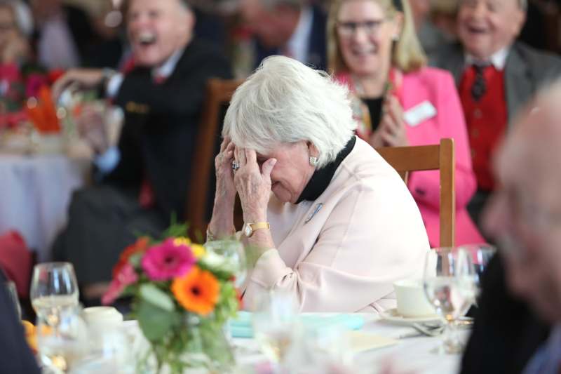 a woman sitting at a table with her hands on her face