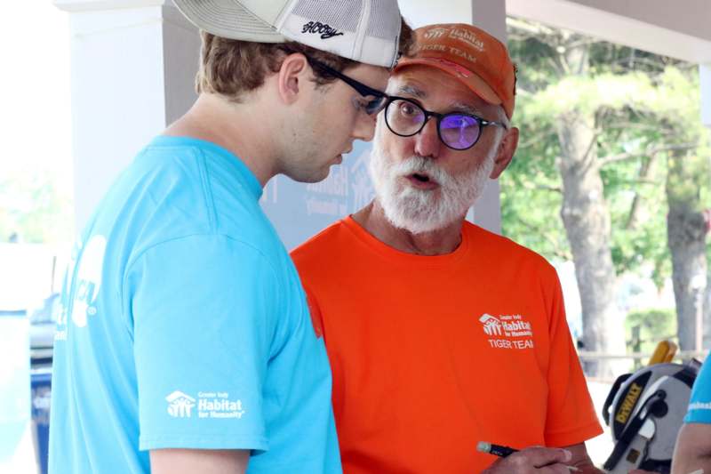a man in glasses and a man in orange shirt