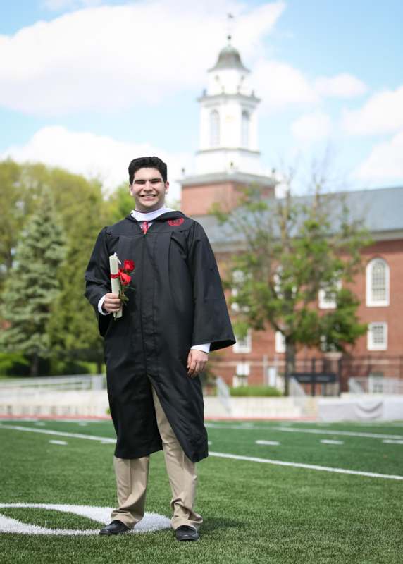 a man in a graduation gown holding a diploma