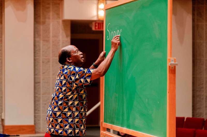 a man writing on a chalkboard