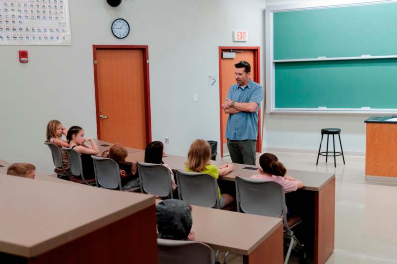 a man standing in front of a classroom with kids