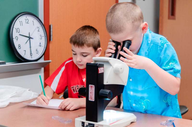 a boy looking through a microscope