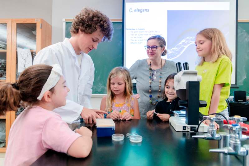a group of children looking at a microscope