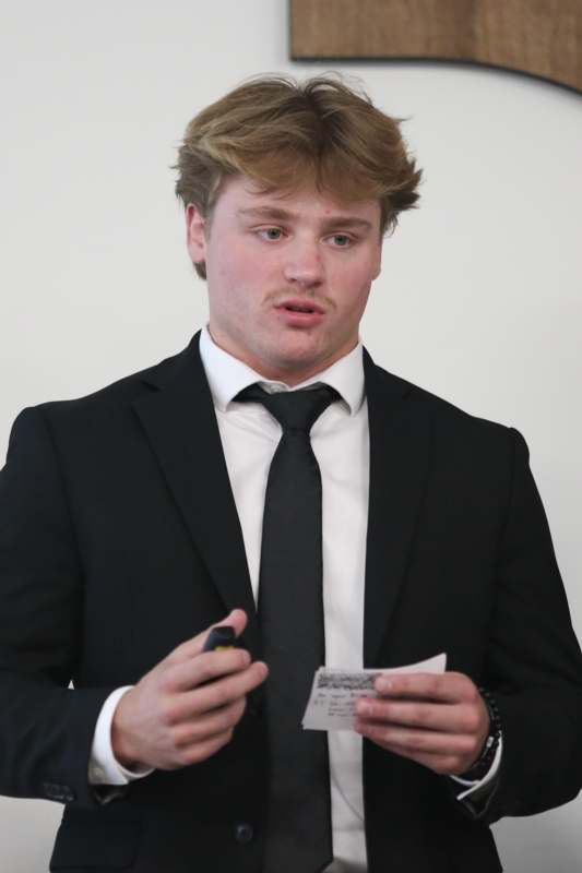 a man in a suit holding a piece of paper and a cigarette