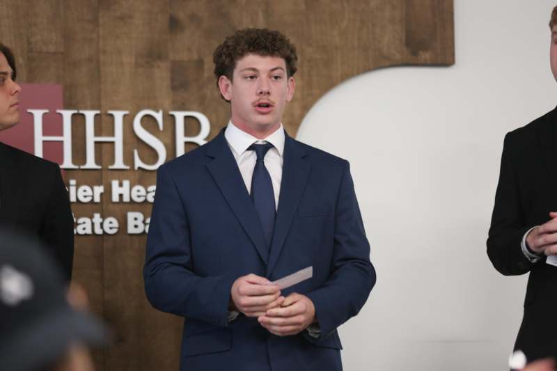 a man in a suit holding a piece of paper