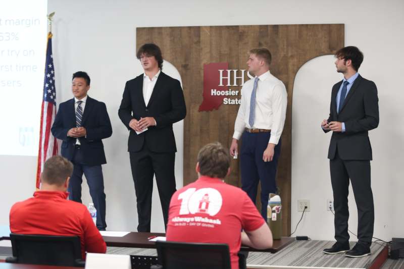 a group of men standing in front of a board