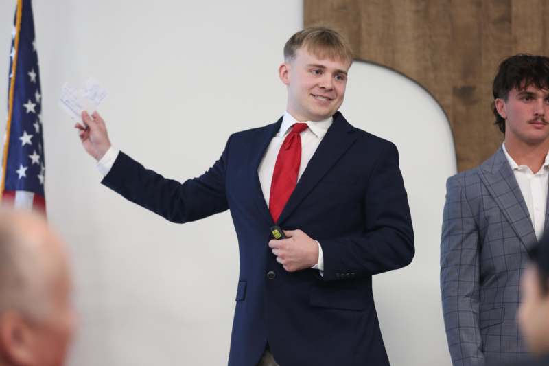 a man in a suit holding a piece of paper