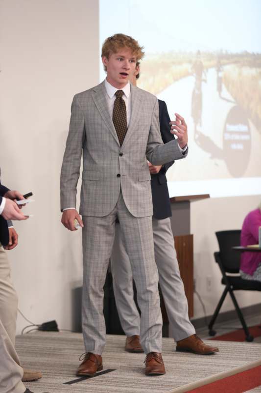 a man in a suit standing in front of a screen