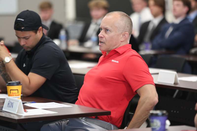 a man in a red shirt sitting at a table