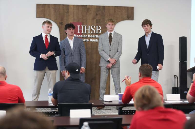 a group of men in suits standing on a table