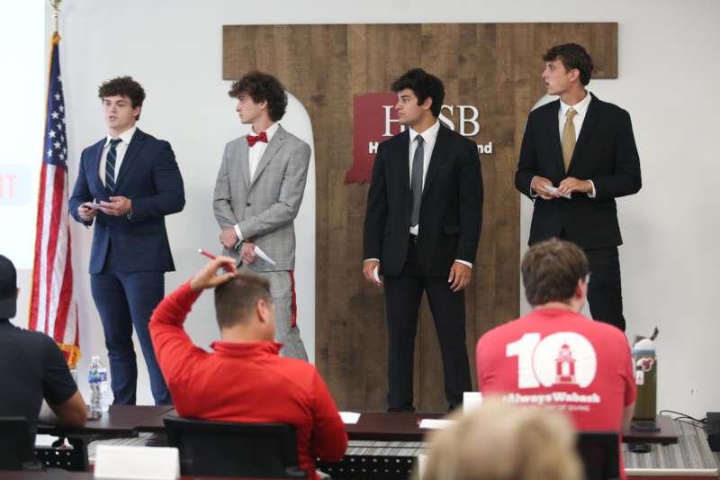 a group of men in suits standing in front of a group of people