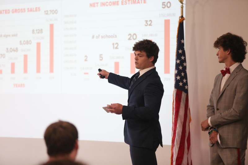 a man in a suit pointing at a screen