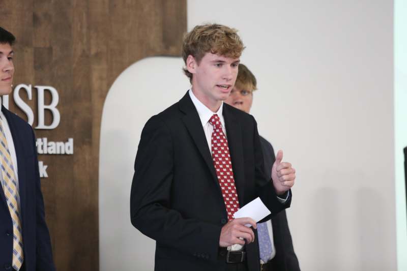 a man in a suit giving a thumbs up