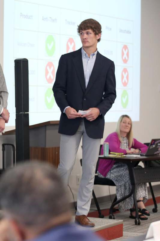 a man standing in front of a projector screen