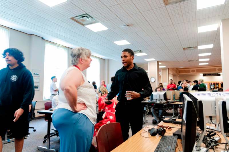 a man and woman in a room with computers