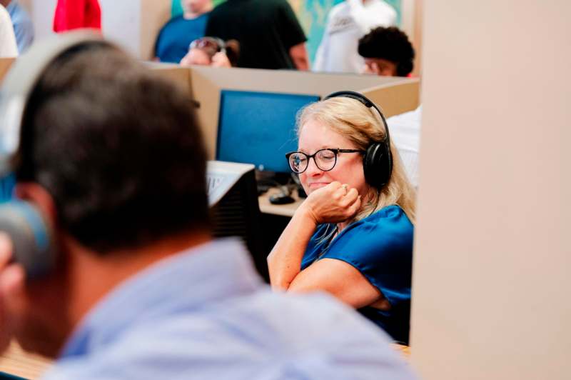 a woman wearing headphones and sitting at a desk