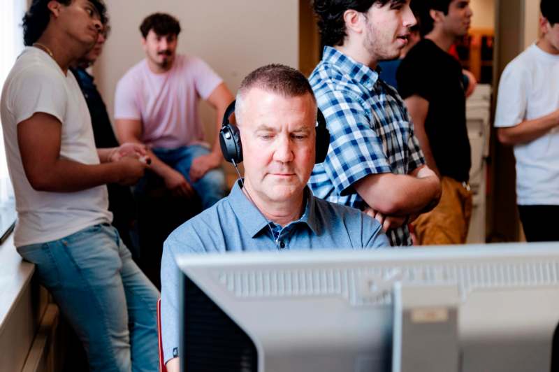 a man wearing headphones looking at a computer screen