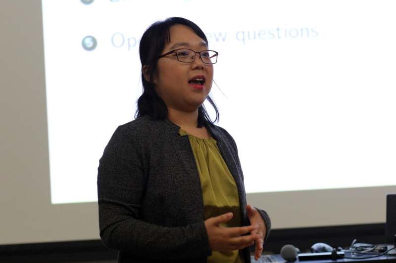 a woman standing in front of a projector screen