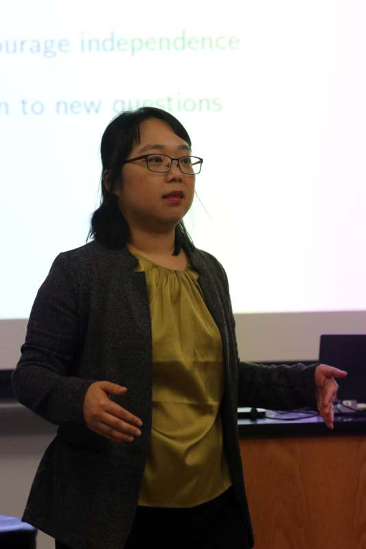 a woman standing in front of a projector screen