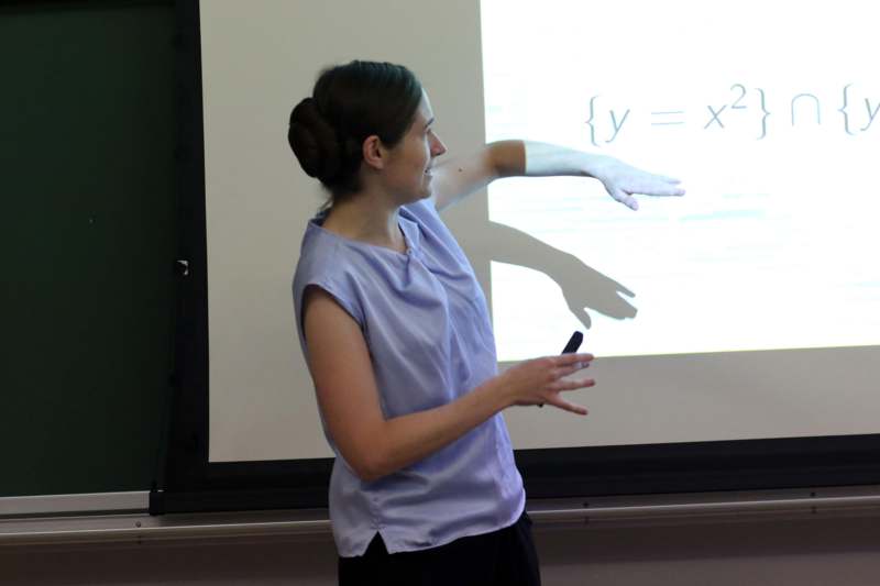 a woman standing in front of a projection screen