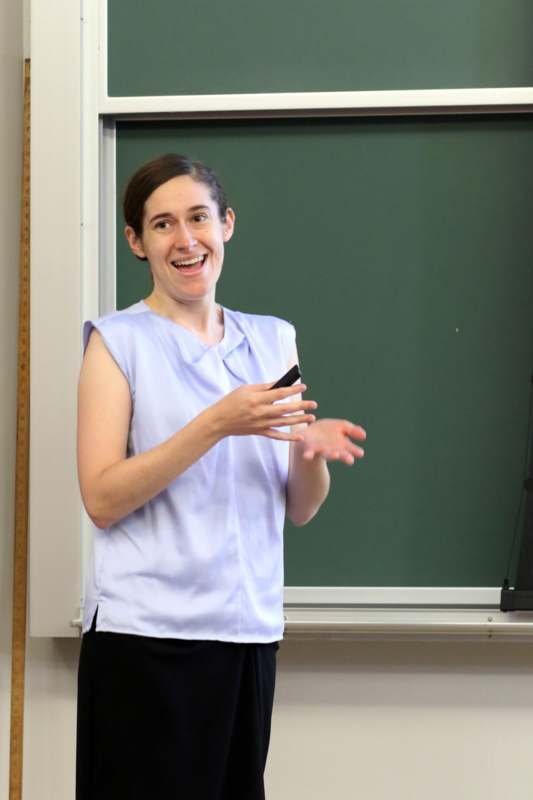 a woman standing in front of a chalkboard