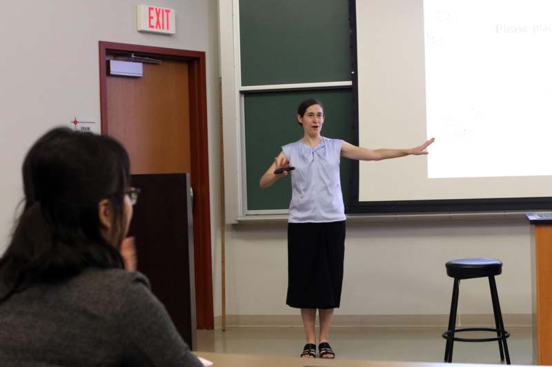 a woman standing in front of a whiteboard