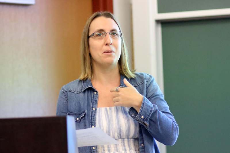 a woman pointing at a piece of paper