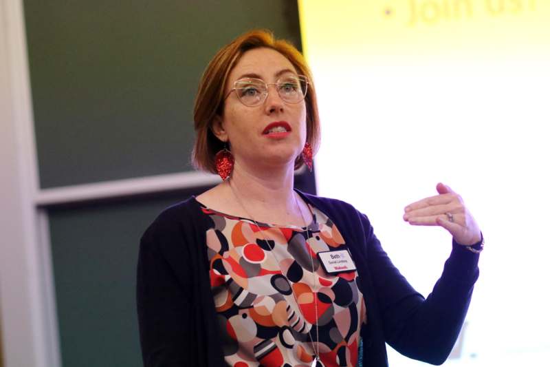 a woman wearing glasses and a name tag