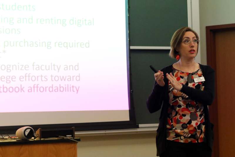 a woman standing in front of a projection screen