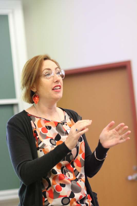 a woman wearing glasses and a colorful blouse