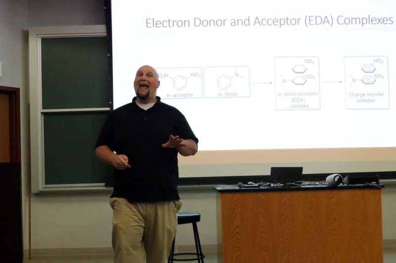 a man standing in front of a projector screen