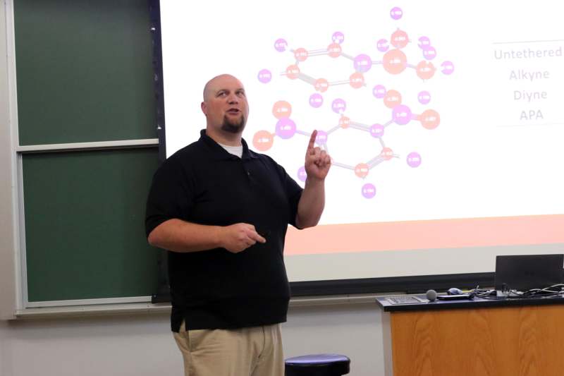 a man standing in front of a projector screen