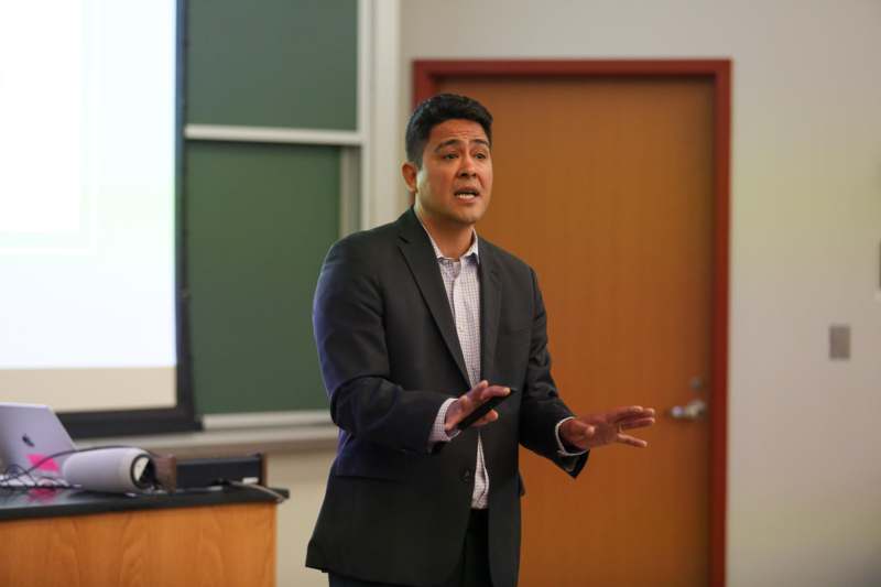 a man in a suit standing in front of a screen