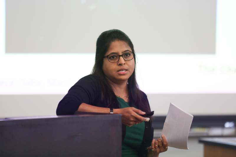 a woman in a green shirt holding a piece of paper