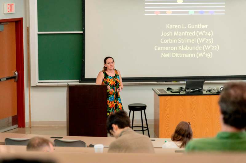 a woman standing at a podium in front of a screen