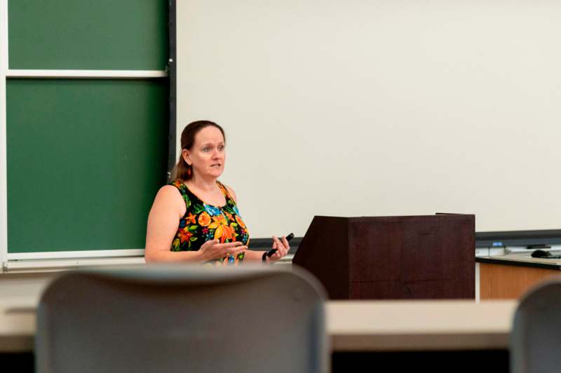 a woman standing in front of a whiteboard