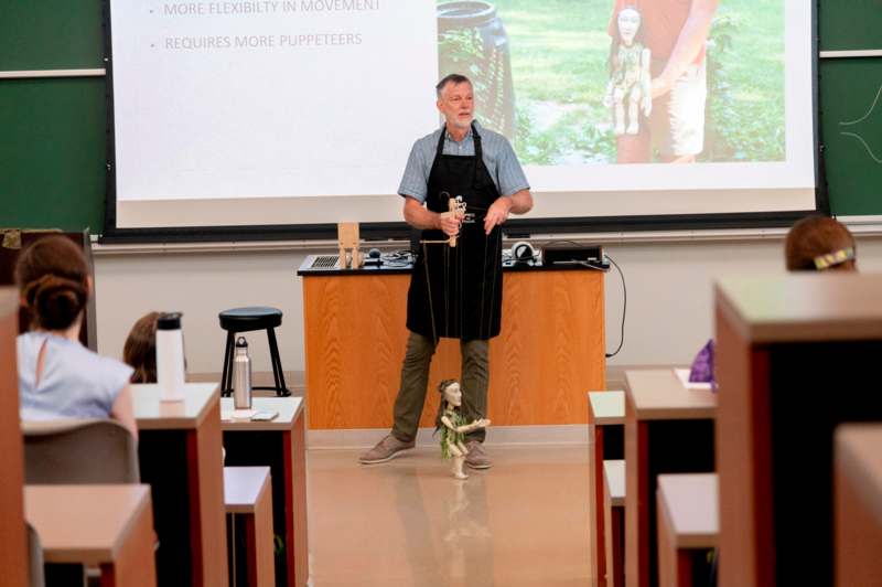 a man standing in front of a projection screen