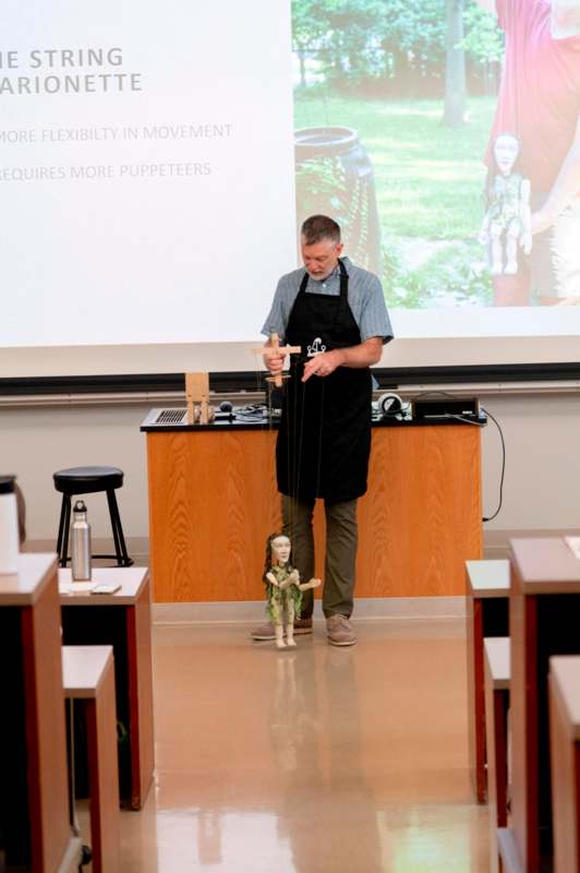 a man in an apron holding a puppet